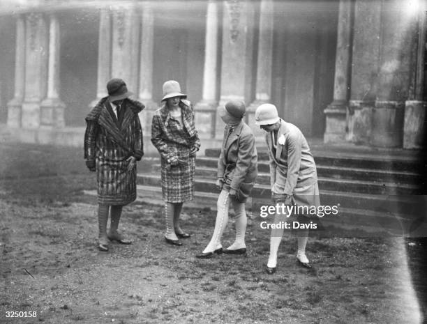 Couple of ladies showing their knee gaiters on their stockings.