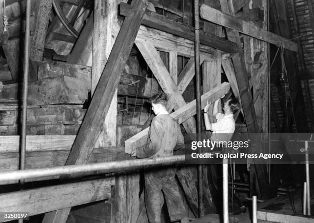 Workmen placing new timbers into position in the belfry as part of the repair and restoration work taking place at the famous Curfew Tower at Windsor...