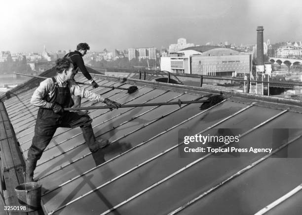 Workmen cleaning the glass roof of Waterloo Station.