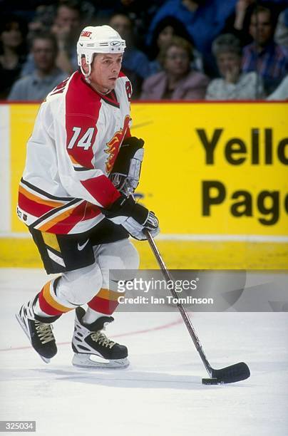 Theoren Fleury of the Calgary Flames controls the puck during the Flames 5-4 loss to the Edmonton Oilers at Canadian Airlines Saddledome in Calgary,...