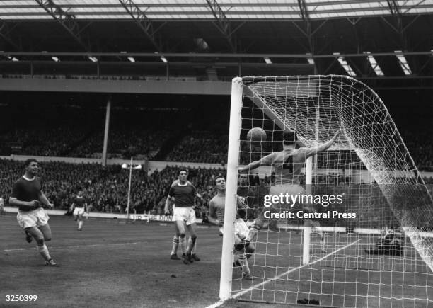 Sutton United's No 4 attempts to make a goal line clearance and prevent a second goal by Wimbledon.