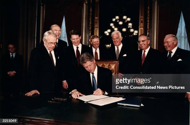 President of the United States Bill Clinton signing his first presidential papers in the President's Room with Senator Wendell Ford, Senator Alan...