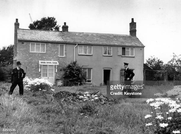 Police stand guard outside Leatherslade Farm at Oakley in Buckinghamshire, used as a hide-out by the Great Train Robbers.