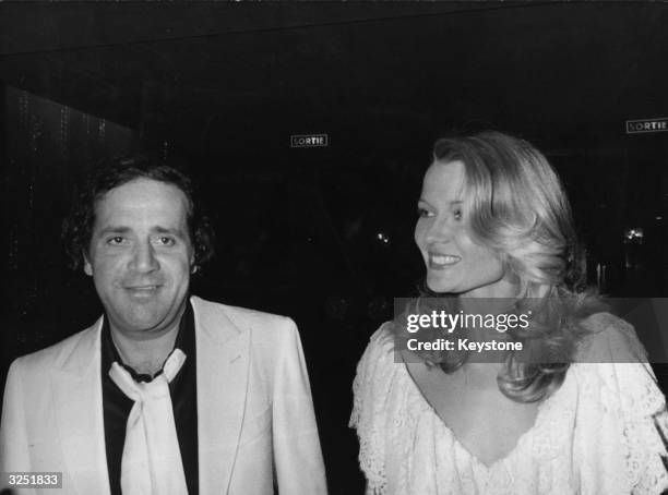 Film producer, Jean Yanne arriving with Mimi Contelier, star of his last film, to see the 'Show of the Century', which stars many famous stars,...