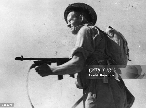 Typical member of the Australian infantry with his Tommy gun who keep the Italian front line troops on edge in the Libyan desert.