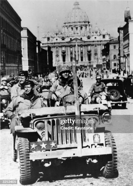 American General Mark Clark in his 3-star jeep rides through Rome, following the liberation of the city by the 5th Army, June 1944. Behind him, sits...