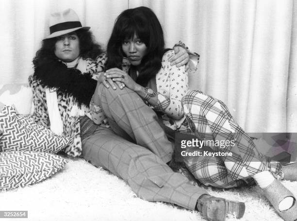 British singer, songwriter and guitarist Marc Bolan , of the pop group T Rex, reclines with his girlfriend, singer Gloria Jones.