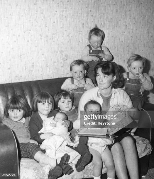 Mary Brocks from Liverpool, 25-year-old mother of nine, including triplets and twins, reading the children a bedtime story.