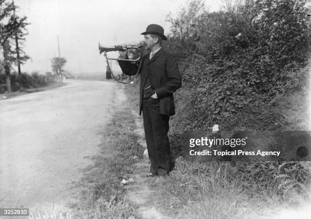 Motor race official blows his bugle to warn of the approach of cars during the Coupe des Voiturettes race at Boulogne.