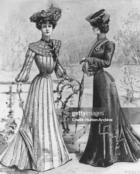 Two women wearing elegant Edwardian street dresses in a park.