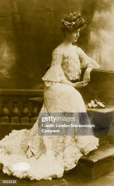 Actress Carol McComas wearing a dress with ruched sleeves, a lace skirt and bustier.