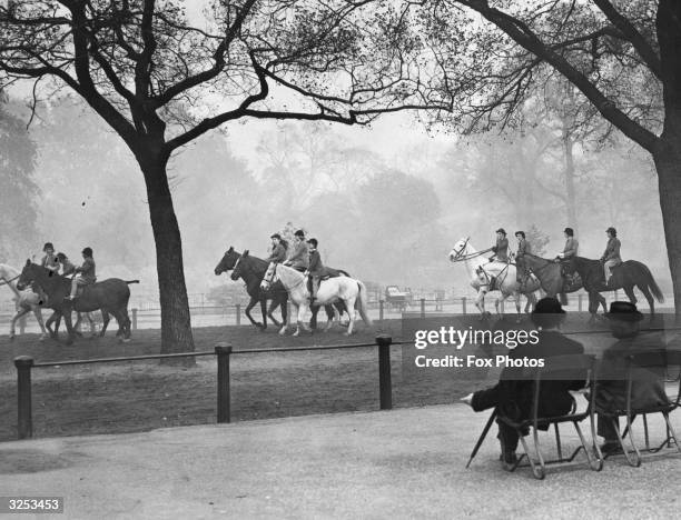 Riders in Rotten Row, Hyde Park, London, in the morning mist.