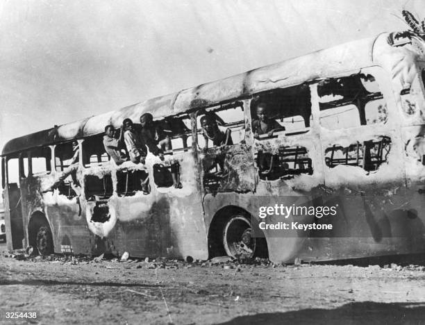 Children play in a burnt out bus following recent rioting in Durban, South Africa over the city's measures to clean up the township.