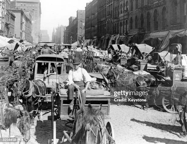 Traders and horses line a busy street during market day in Chicago.