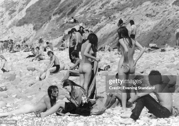 Hippies at the Isle of Wight Pop Festival strip down on the beach during a break from the music.