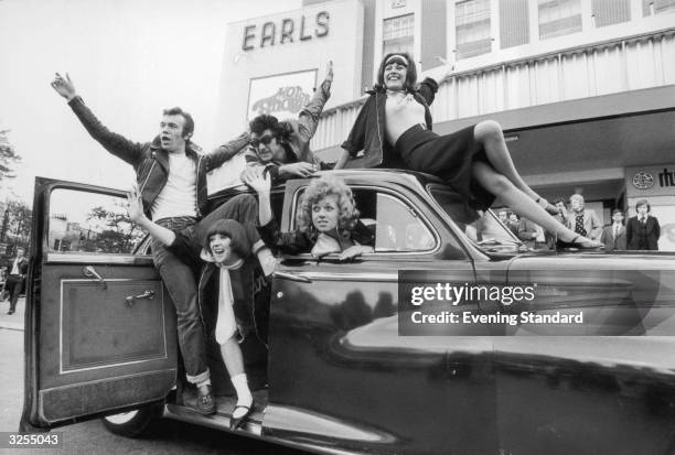 The cast of the show 'Grease', a new 1950's rock and roll musical, arrive at Earls Court London for the 1973 Motor Show driving a Chrysler Windsor...