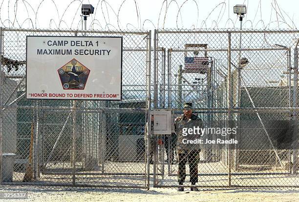 Army soldier stands at the entrance to Camp Delta where detainees from the U.S. War in Afghanistan live April 7, 2004 in Guantanamo Bay, Cuba. On...
