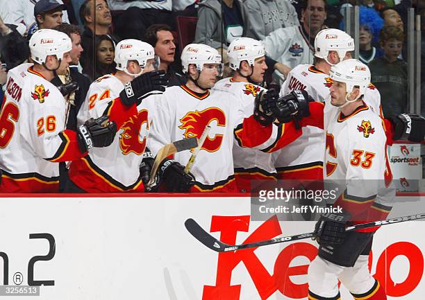 Krzysztof Oliwa of the Calgary Flames is congratulated by his teammates after scoring a third period goal against the Vancouver Canucks in their...