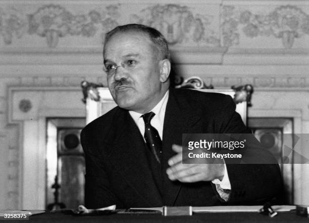 Viatcheslav Mikhailovitch Molotov , Soviet politician and diplomat, at his desk answering press questions at the Soviet Embassy.