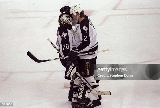 Goaltender Ed Belfour and Derian Hatcher of the Dallas Stars hug during the Stars 3-2 NHL Playoff win over the San Jose Sharks at Reunion Arena in...