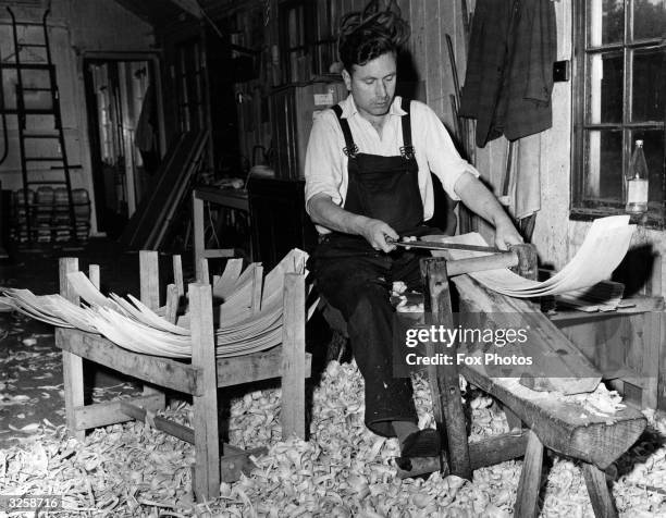 Reg Saunders crafts a trug basket from willow and sweet chestnut using a traditional foot-operated machine.