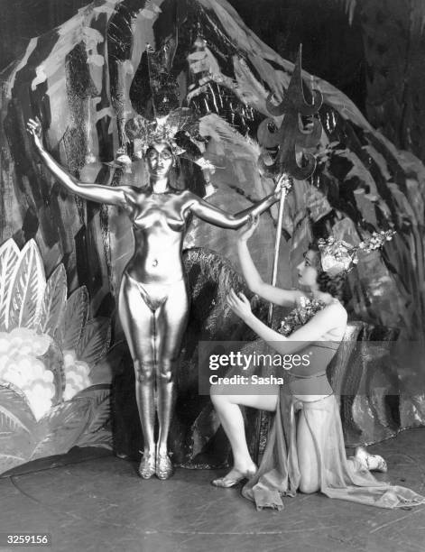 Topless showgirl, covered in gold paint, on stage with a colleague at the Prince of Wales Theatre, Leicester Square, in the production 'Frivolities...