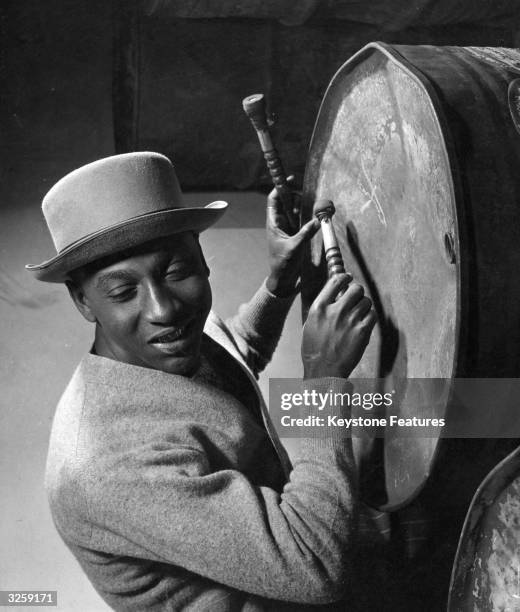 Dudley Smith tunes his Boom and listens to check on the pitch. The Boom is a large metal dustbin, with its bottom pierced.