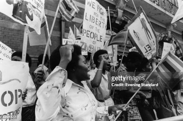 People protest outside Lancaster House, London, where they await the arrivals of the delegates to the Rhodesia Conference. Rhodesia became an...