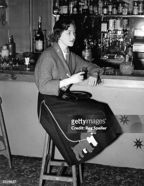 Miss Jennifer Hall enjoying a drink at the bar of the 'Bear Hotel', Maidenhead. She is fashionably dressed in a poodle cloth jacket and felt skirt,...