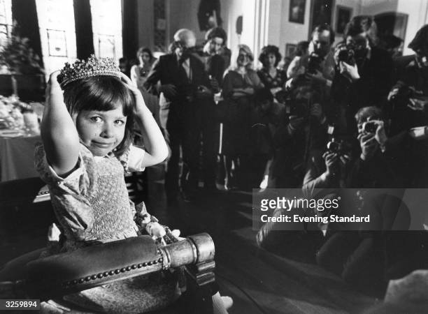 Young newly-crowned beauty queen Christine Cashman is photographed sitting on her throne.
