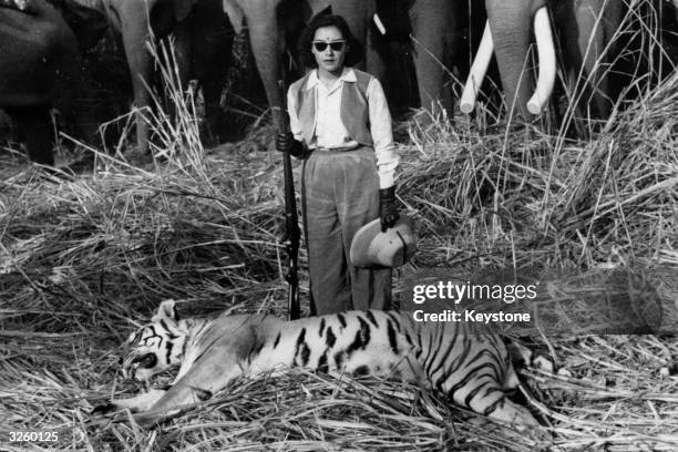 Queen Ratna Rajya Lakshmi Devi, wife of King Mahendra of Nepal, with a tiger she shot during a big game hunt in the jungle.