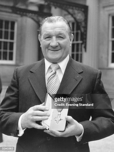 Bob Paisley manager and former player of Liverpool Football Club, shows off his MBE.