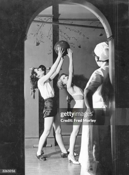 The classical dancer and body culture expert, Rosemary Andree, instructing one of her pupils in an exercise designed to give graceful movement. She...