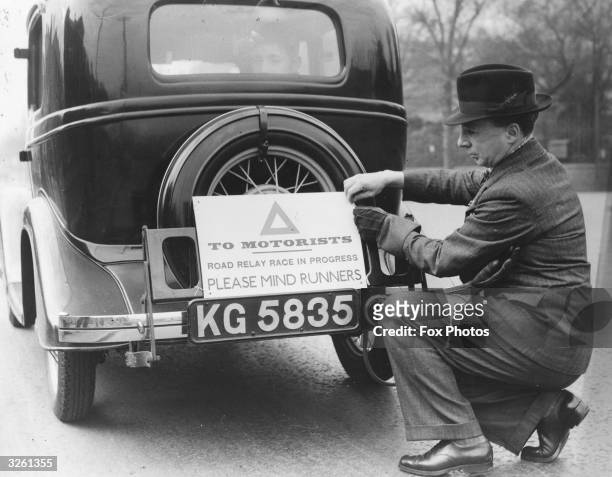 An official puts a notice on the rear of the car at the start of the sixth annual Newport-Cardiff-Swansea road relay race. A letter from the Mayor of...