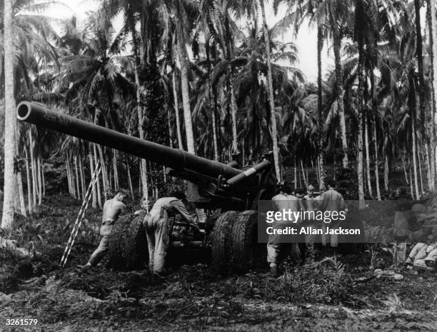 155mm cannon, manned by American troops, is poised strategically on Rendova Island to reach the Japanese stronghold on nearby Mjnda.
