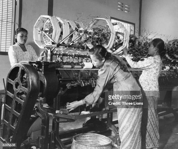Women work at spinning machine in Indonesia.
