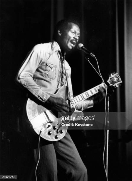 Hugely influential singer, songwriter and guitarist Chuck Berry, , performing on stage with his guitar at the Birmingham Odeon in England.