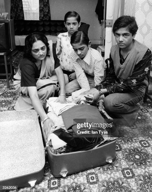 Mrs Manju Patel and her three sons packing a suitcase at their home in Gillingham, Kent, after the Home Office decided to deport them to India for...