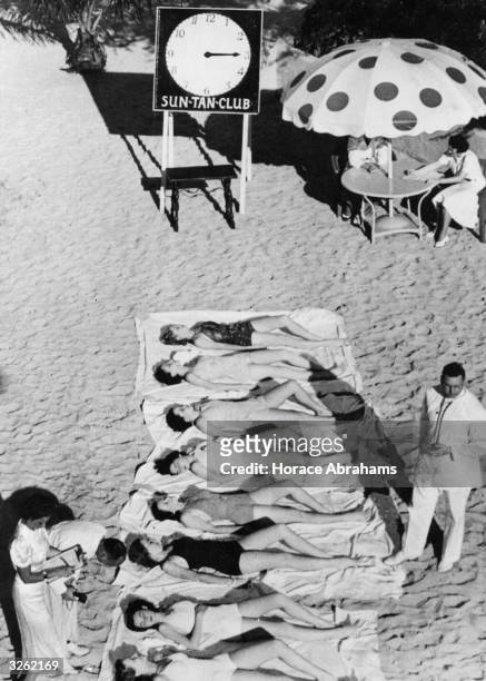 Members of the Miami Biltmore Country Club Sun Tan Club sunbathing for an hour under the supervision of a doctor and his attendants, at Coral Gables,...