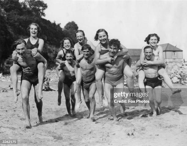 Holidaymakers enjoy a piggyback race on the sands at Barry.