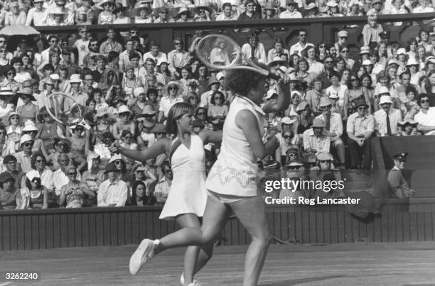 Chris Evert and Martina Navratilova in action together on the doubles court at the Wimbledon Tennis championships, where they beat Billie Jean King...