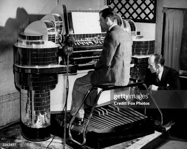 Mr John Chester, pub licensee, listens as organist Vick Smith plays the organ which he has had installed in his pub The Earl of Derby, Forest Gate,...