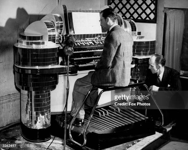 Mr John Chester, pub licensee, listens as organist Vick Smith plays the organ which he has had installed in his pub The Earl of Derby, Forest Gate,...
