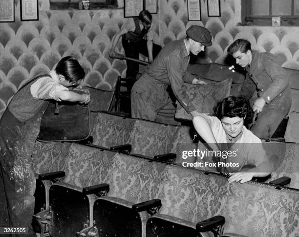 Members of an amateur dramatics society called the Incognito Players installing old cinema seats in the theatre they are building themselves.