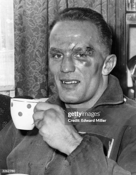 British boxer Henry Cooper having a cup of tea the morning after a big fight.