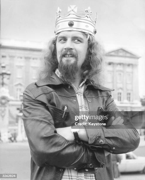Scottish comedian Billy Connolly poses in front of Buckingham Palace.