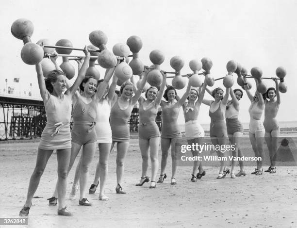 Group of women exercising on the beach at Worthing using new inflated 'swim bars'.