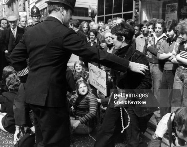 Mrs Rose-Marie Davis, wife of the convicted armer robber is pictured being escorted to a police van, having been cut from chains in Fleet Street. She...