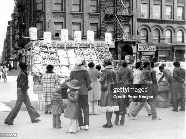 Shoppers at a fruit and vegetable stall in Harlem, New York.