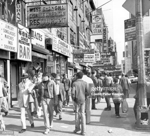 Shoppers on West 42nd Street between 7th and 8th Avenues in the Times Square area of New York.